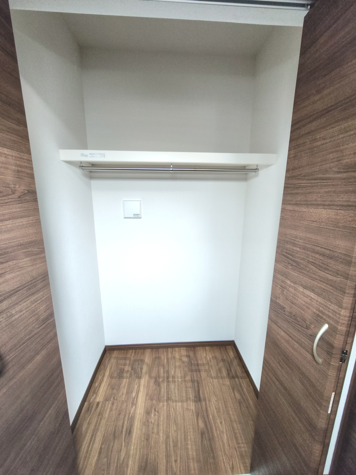 京都府八幡市八幡小松の賃貸物件 木目調フローリングのクローゼット内部と収納棚