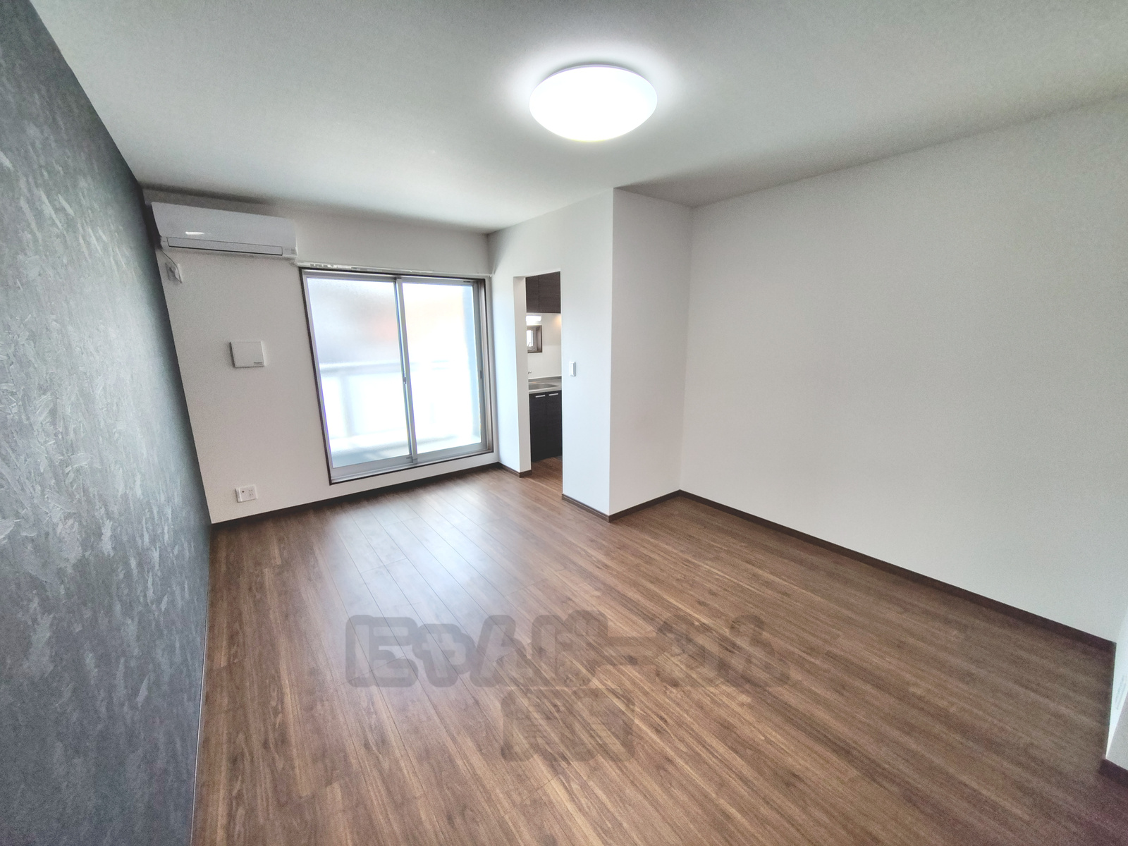 京都府八幡市八幡小松の賃貸物件 グレーのアクセントクロスとエアコンのある洋室