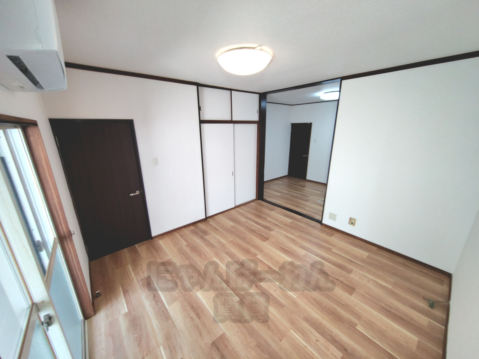 京都府宇治市神明石塚の犬・猫ペット可賃貸物件の居室。木目調の床に壁掛けエアコンと収納用の引き戸が備わっています。