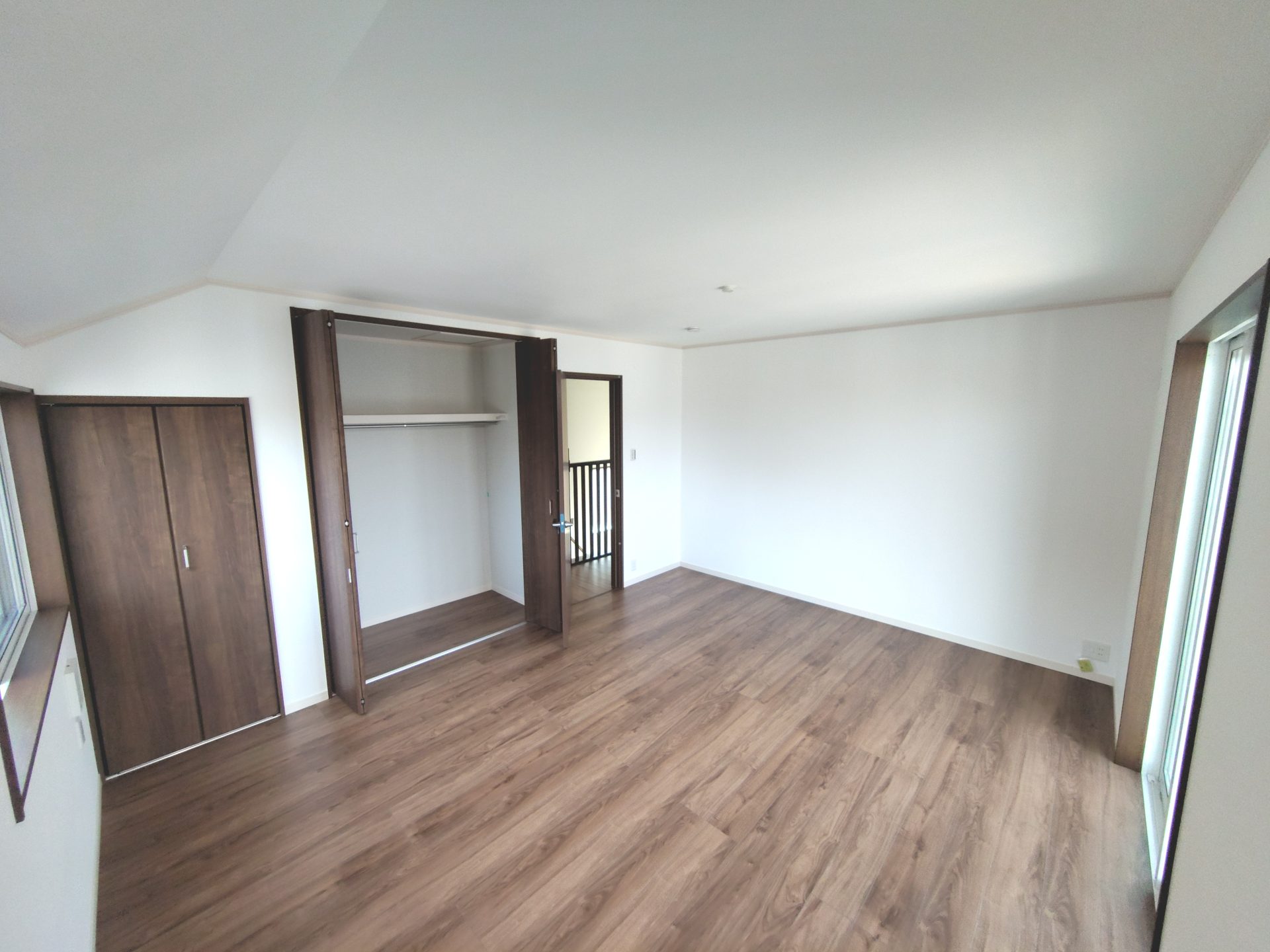 京都府京田辺市薪里ノ内のペット可賃貸物件の洋室。複数の収納スペースとバルコニーへ続く窓がある部屋。