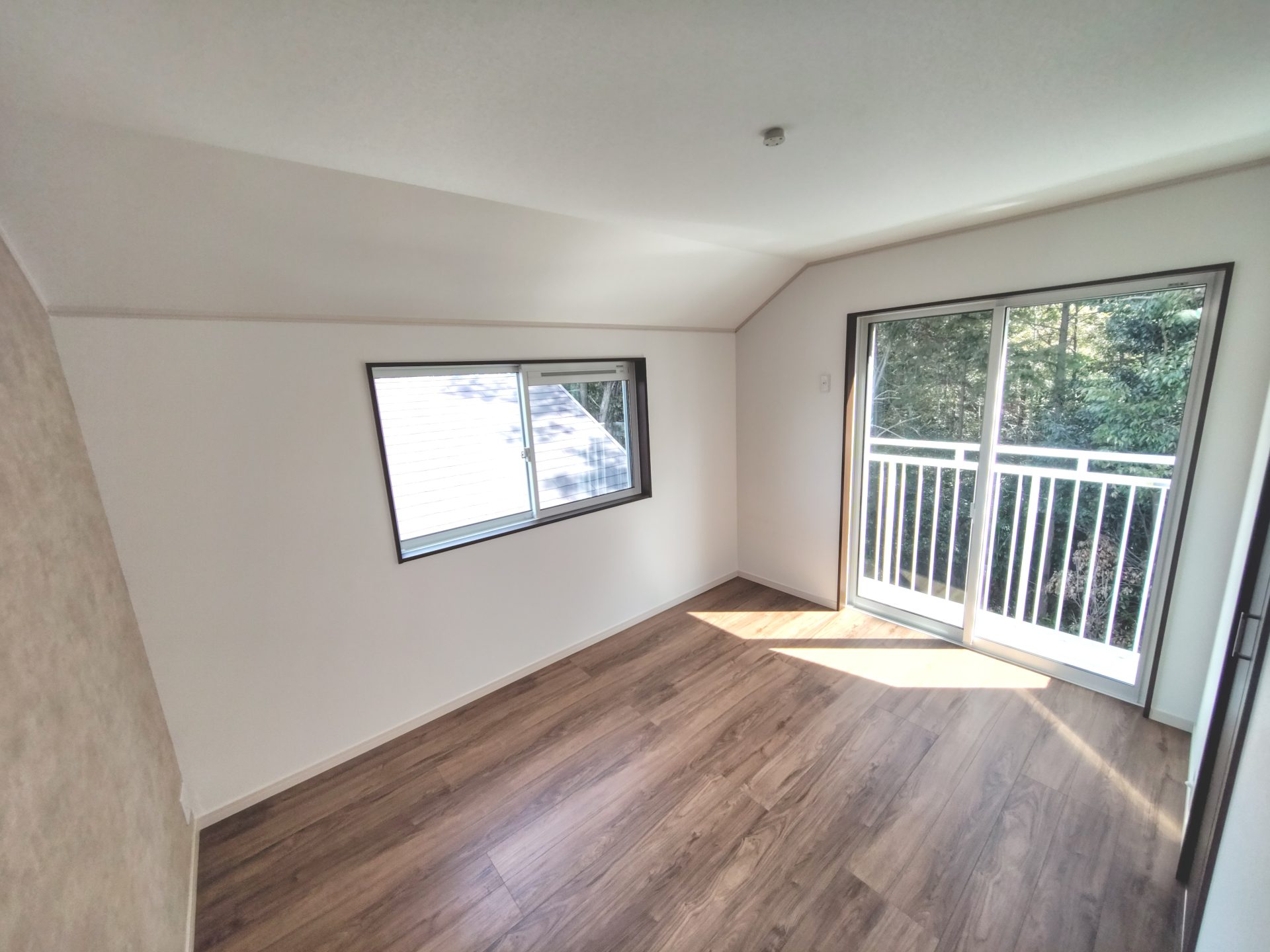 京都府京田辺市薪里ノ内のペット可賃貸物件の洋室。外の緑が見えるバルコニーと小窓がある部屋。