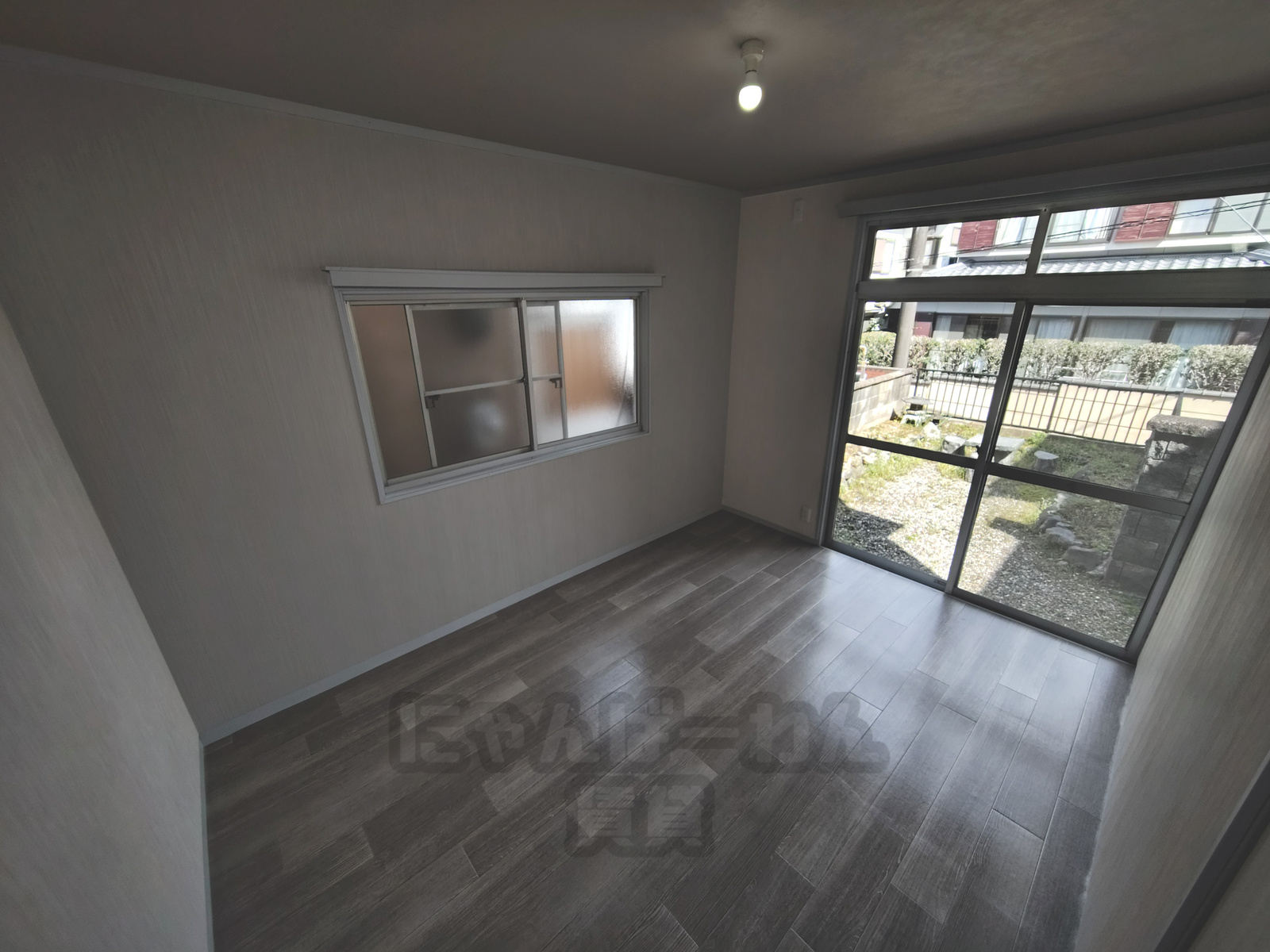 京都府宇治市木幡御蔵山のペット可（犬・猫）賃貸物件の木目調フローリングの洋室と庭へ繋がる掃き出し窓