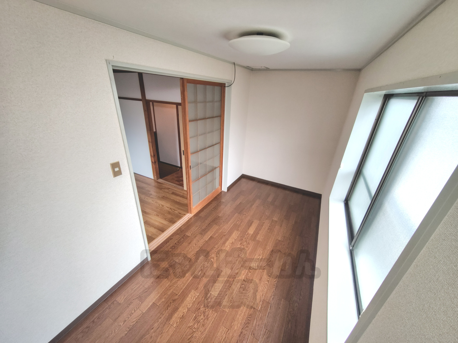 京都市山科区四ノ宮小金塚のペット可賃貸の洋室。採光のある窓とフローリング床、隣室への引き戸