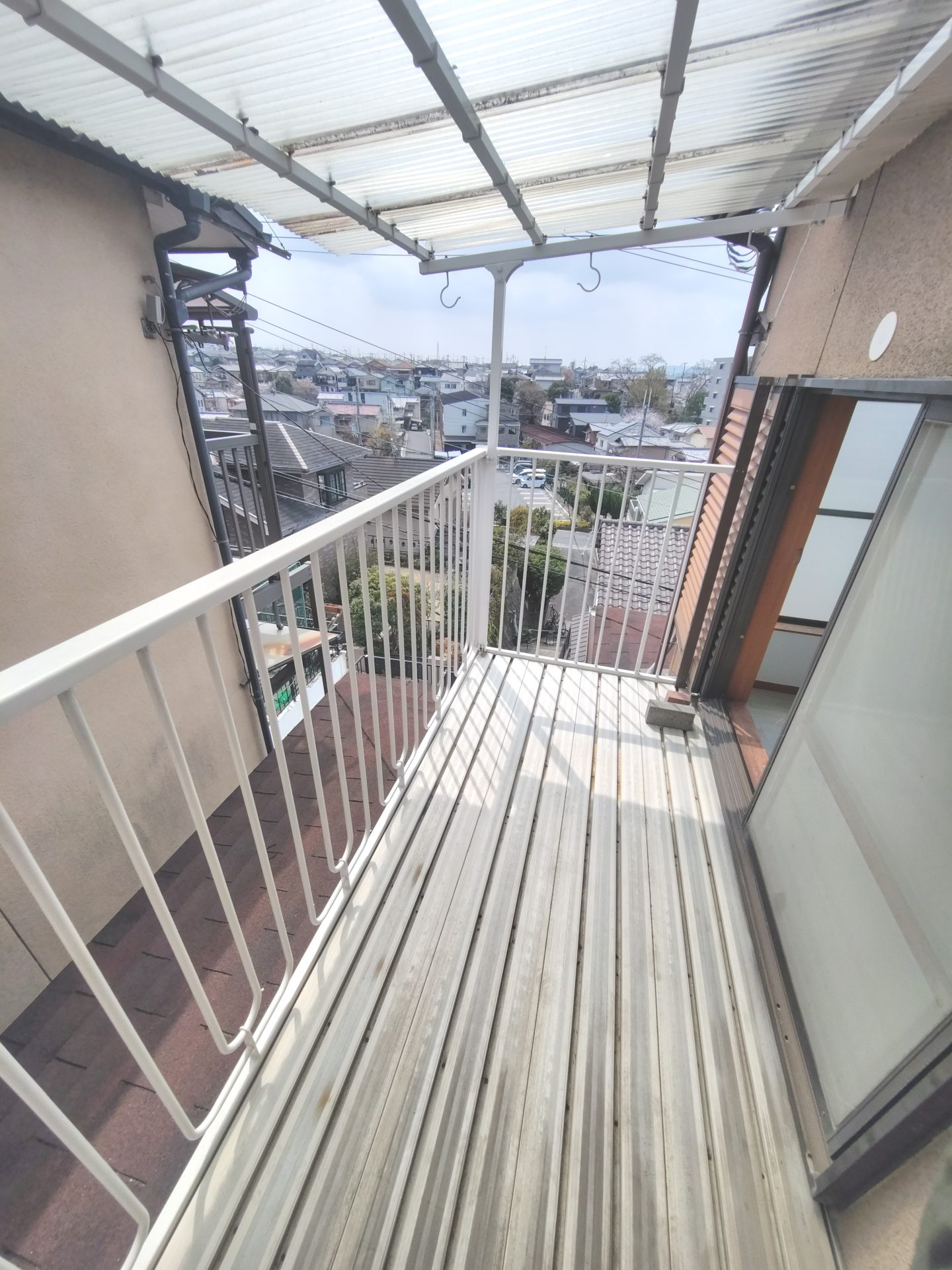 京都府宇治市広野町丸山のペット可賃貸物件の波板屋根付きバルコニーと周辺の街並み