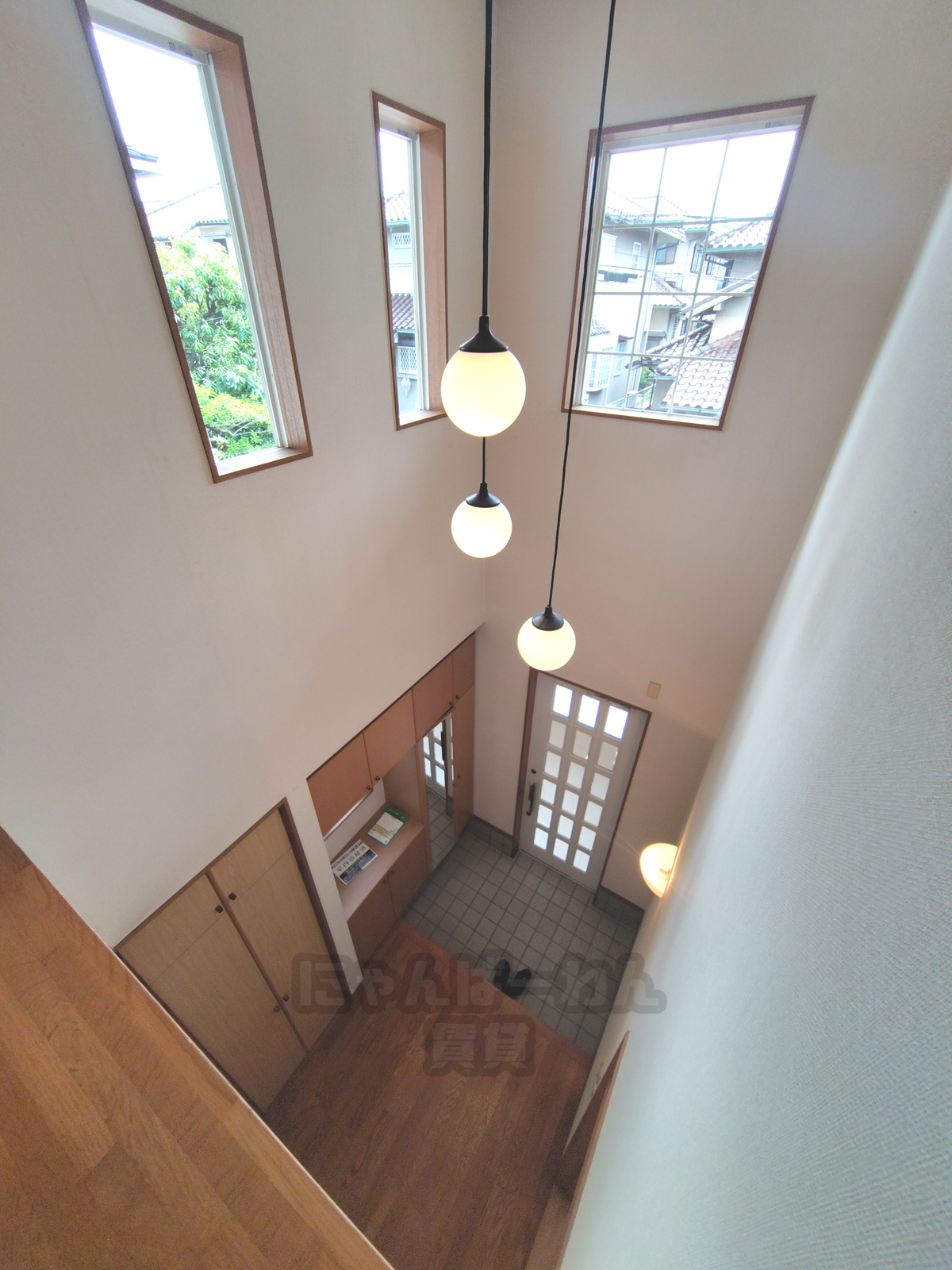 吹き抜けとペンダントライトのある開放的な玄関ホール（京都府宇治市寺山台のペット可賃貸物件）