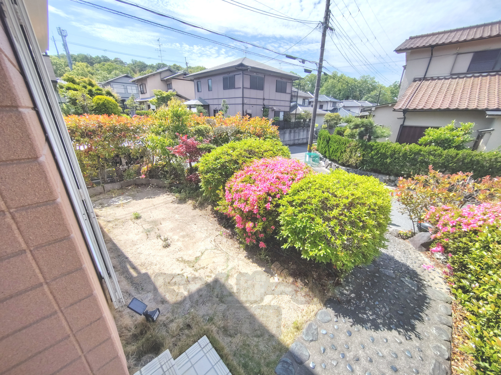 京都府城陽市寺田深谷のペット可戸建て賃貸の庭とアプローチ。緑豊かな植栽と石畳の通路