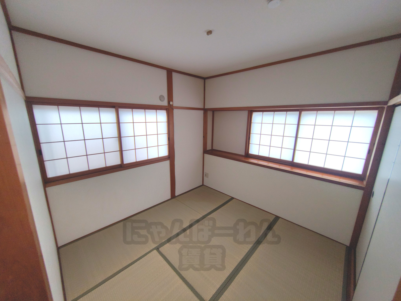 京都府城陽市寺田宮ノ谷の賃貸物件（ペット可）の和室。榻榻米、白い天井、2面に障子窓が配置された、日当たりの良い部屋の隅。