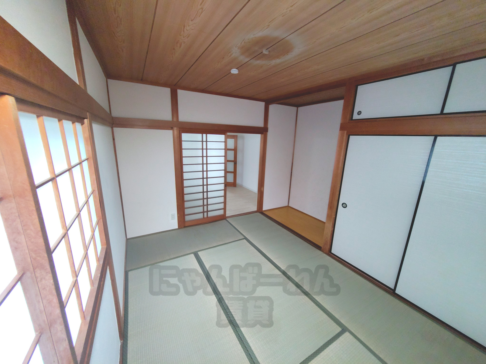 畳の和室。障子窓、押し入れ（襖）、板張りの天井。