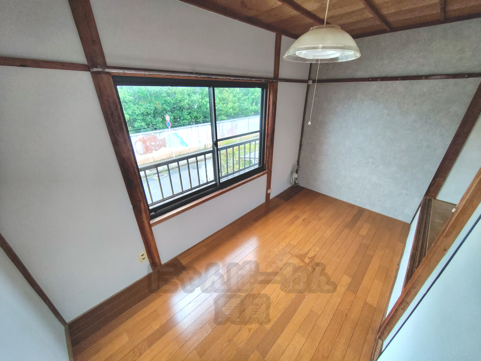 京都府宇治市五ケ庄新開のペット可賃貸物件。木目調フローリングと大きな窓から緑が見える洋室。
